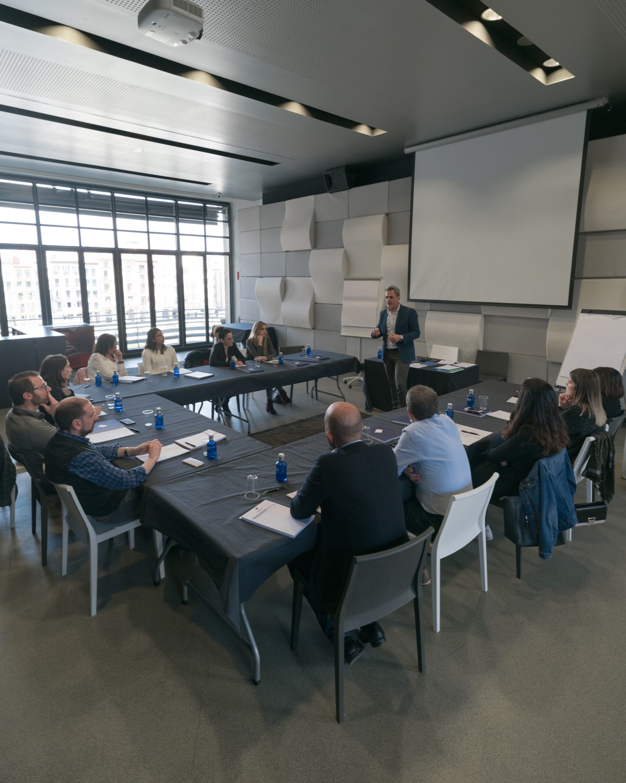 Equipo directivo en una reunión con tensión y falta de alineación, representando los conflictos empresariales que Ricard González ayuda a resolver para recuperar rendimiento y armonía.